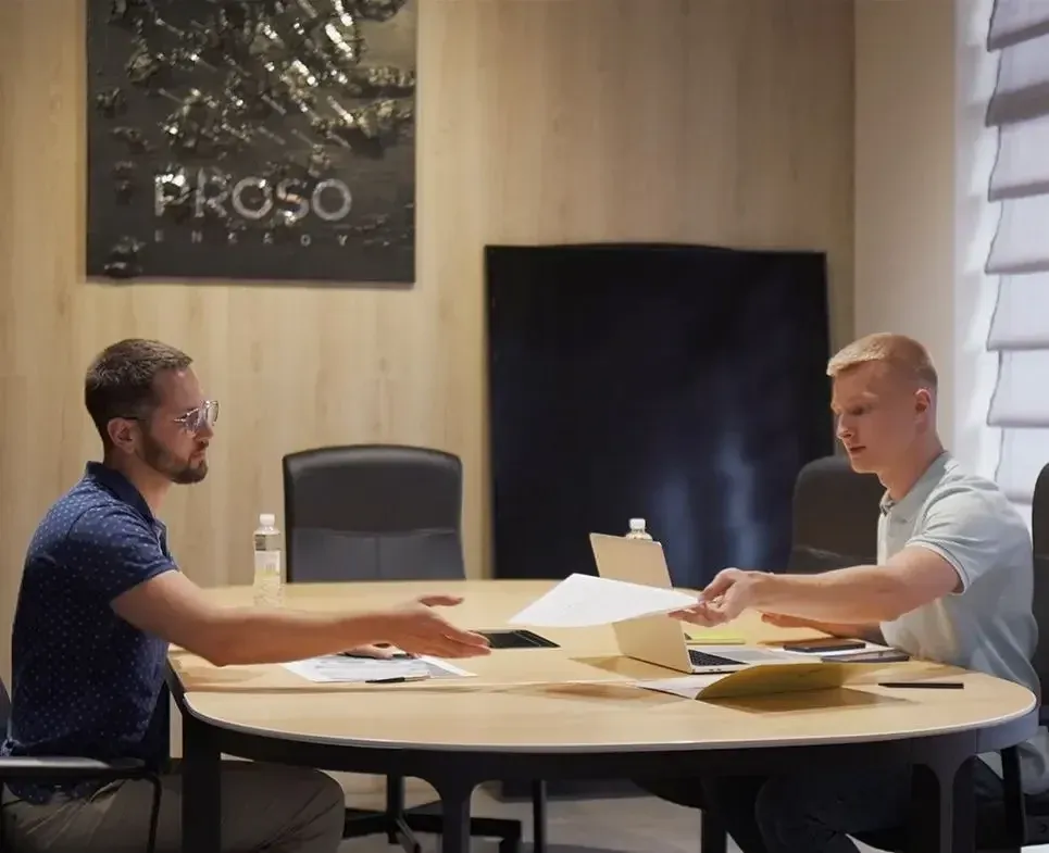 Proso Energy - Двоє людей у офісі щось обговорюють за робочим столом